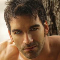 Sexy masculine man shirtless outdoors against tree